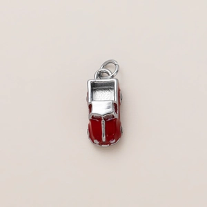 Dettaglio ravvicinato di un ciondolo auto in smalto rosso con accenti argentati e anello
