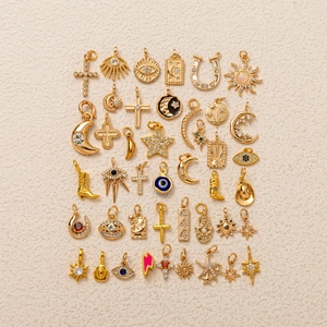 Détail de 36 breloques dorées DIY avec des motifs célestes et des icônes bohèmes