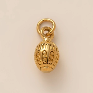 Vue macro d'un pendentif papillon en nacre plaqué or 18K avec des gravures évidées