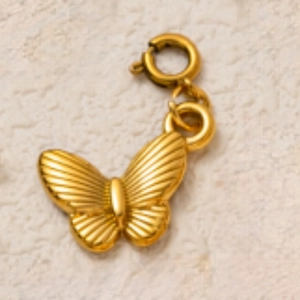Détail macro d'un pendentif papillon doré avec texture rayons de soleil et fermoir