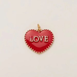 Gros plan du pendentif cœur en émail rouge avec lettrage LOVE doré et bordure perlée