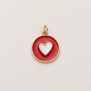 Détail du pendentif en forme de cœur plaqué or avec émail rouge et cœur blanc inséré