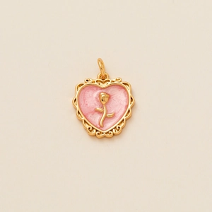 Détail d'un pendentif cœur vintage avec émail rose et une rose dorée en relief