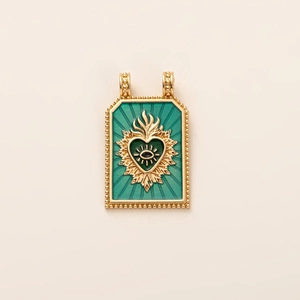 Gros plan détaillé d'un pendentif tarot doré avec émail vert et cœur sacré mystique