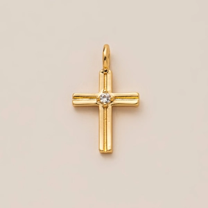 Détail d'un pendentif croix plaqué or 18 carats avec un zircon central étincelant