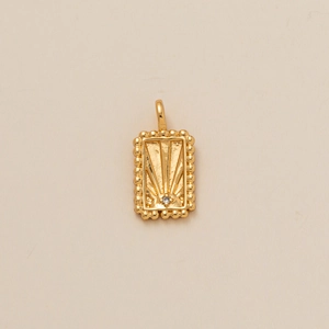 Vue macro du pendentif solaire rectangulaire plaqué or avec zircon et bordure perlée