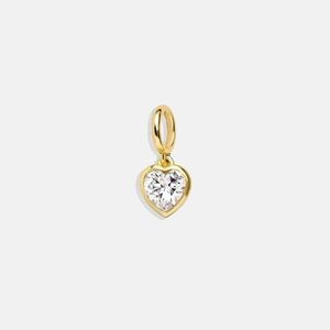 Détail du pendentif en forme de cœur doré avec une pierre précieuse taillée en cœur