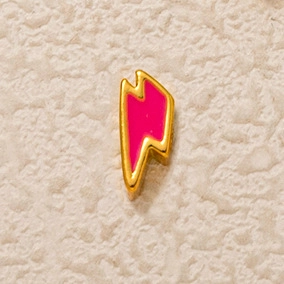 Détail du pendentif éclair en métal doré avec un remplissage en émail rose vif
