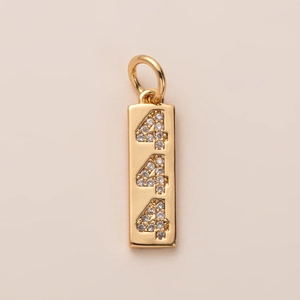 Détail d'un pendentif rectangulaire doré avec chiffres 444 sertis de zircons cubiques