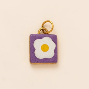 Dettaglio di un ciondolo in acciaio inossidabile placcato oro 18K con smalto viola