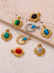 Dettaglio macro di ciondoli ovali retrò con placcatura in oro 18k e incisione a raggiera