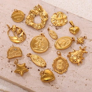 Varios colgantes geométricos de acero inoxidable bañados en oro de 18k sobre piedra