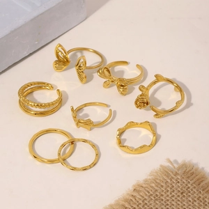 Set of 8 gold PVD plated stainless steel irregular open rings with butterfly and floral motifs