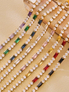 Close-up of golden tennis bracelets with colorful zircon stones in a refined prong setting