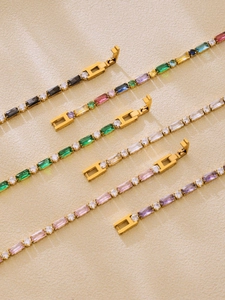 Dettaglio macro di bracciali tennis con zirconi rettangolari colorati e chiusura oro