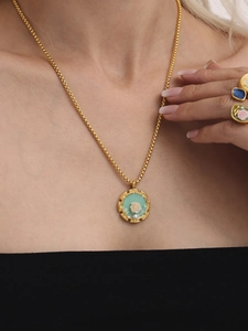 Dettaglio della collana vintage in smalto rosa e set di anelli abbinati