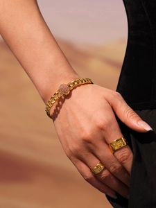 Detail of 18k gold plated Cuban chain bracelet with pink zircon on a female model