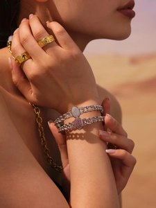 Detail of 18k gold plated NK chain bracelets with sparkling zircon and relief rings