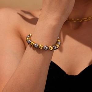 Bracelet en perles creuses en acier inoxydable plaqué or 18 carats sur le poignet