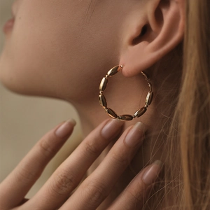 Polierte, 18 Karat vergoldete Creolen mit Perlenkettendesign an einem Fashion-Model