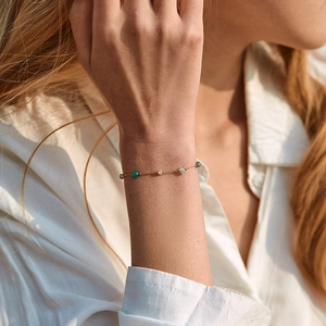 Exotisches Kristallarmband mit türkisfarbenen Perlen und 18K Goldkette am Handgelenk