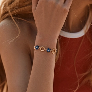 Summer beach style gold flower bracelet with blue gems and crystals on a model wrist