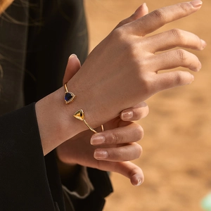 Minimalist 18K gold-plated cuff bracelet featuring a triangular emerald green glass stone