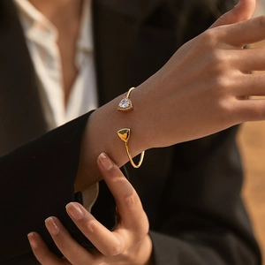 Minimalist brass 18K gold-plated open bangle with emerald-cut glass stone on wrist