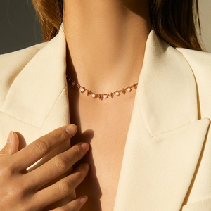 Minimalistische Halskette in Gold mit weißen Kristallperlen zu einem beigen Blazer
