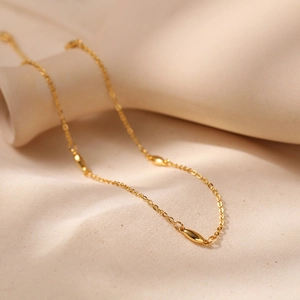 Vista de detalle del collar de latón chapado en oro 18K con cuentas de olivo