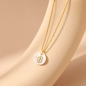 Détail du collier plaqué or 18 carats avec pendentif en nacre et gravure de la lettre B