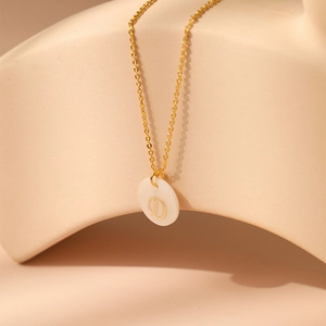 Détail du collier en laiton plaqué or 18K avec initiale D sur pendentif en nacre
