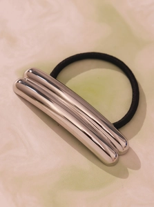 Macro shot of minimalist silver metal hair tie with polished mirror finish bar