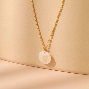 Détail du collier en laiton plaqué or 18 carats avec pendentif lettre G en nacre naturelle