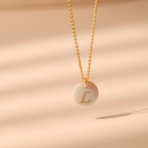Détail du collier plaqué or 18 carats avec pendentif en nacre et la lettre L