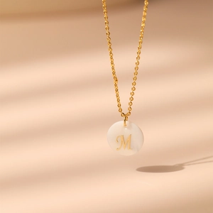 Détail du collier en laiton plaqué or 18K avec pendentif nacre blanche et lettre M