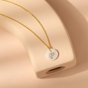 Vue macro détaillée du collier plaqué or 18 carats avec pendentif en nacre blanche et lettre P