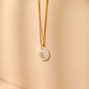 Gros plan détaillé du collier plaqué or 18 carats avec pendentif en nacre et lettre R