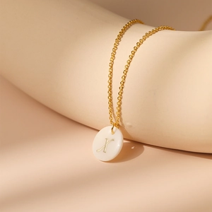 Gros plan d'un collier plaqué or 18 carats avec pendentif perle ronde et lettre X