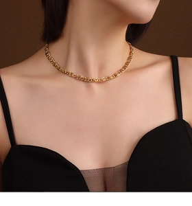Makrodetail der goldenen Halskette mit spiralförmigen Gliedern am Ausschnitt des Models