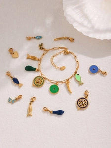Detail view of 18k gold plated stainless steel bracelet with colorful enamel fish charms