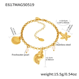 Dettaglio di un bracciale dorato in acciaio inossidabile con conchiglie e perle naturali