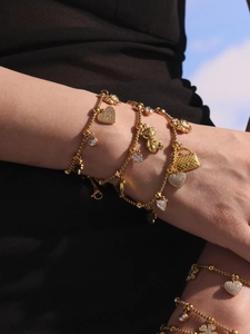 Vergoldetes Armband mit 5A Zirkonia Herz- und Schleifenanhängern am Handgelenk