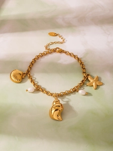 Dettaglio del bracciale con conchiglie dorate, perle naturali e chiusura regolabile in acciaio