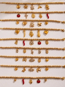 Detailed view of gold bamboo link bracelets featuring assorted fashion charms and zircons