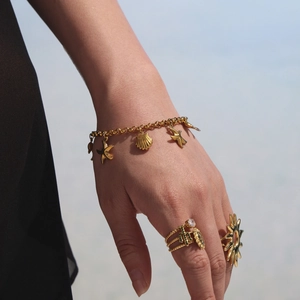 Bracciale perle stella marina dorata con anello in pietra verde per un look da mare