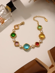 Detalle de pulsera de cristales de colores con cadena de acero dorado y cierre de mosquetón