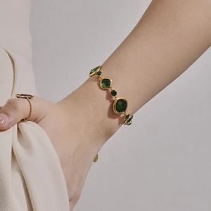 Pulsera vintage dorada con piedras de cristal checo verde lucida en la muñeca mujer