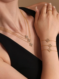 Detailansicht der goldenen mehrlagigen Kleeblatt-Halsketten und Armbänder mit Zirkonia
