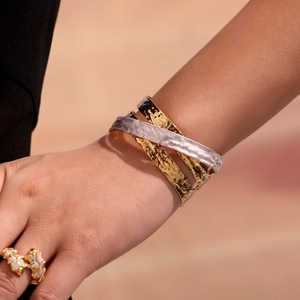 Bracciale a strati martellato a tre colori e anello a farfalla d'oro sul modello
